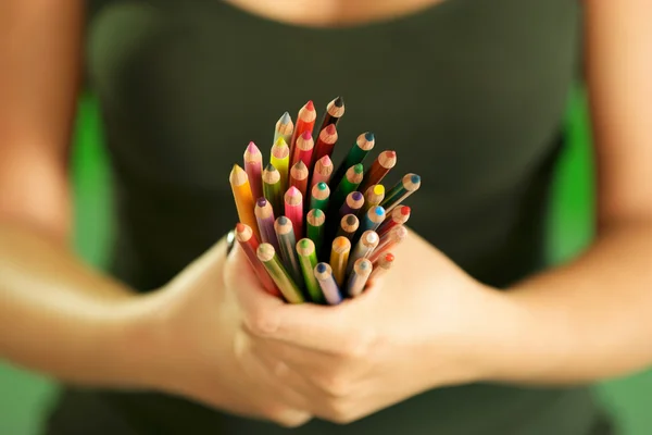 Молодая художница держит цветные карандаши перед камерой — стоковое фото