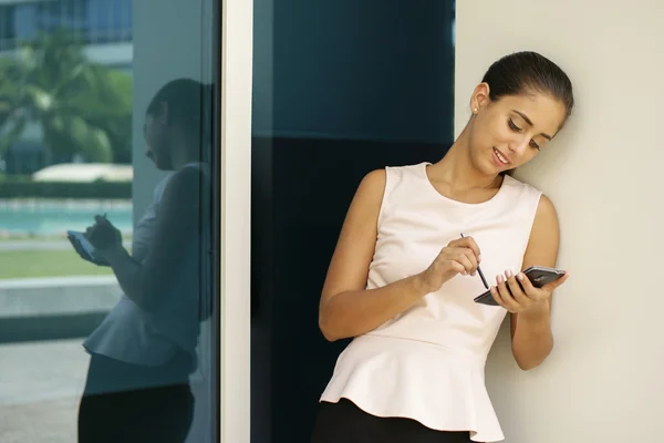 Glückliche Geschäftsfrau tippt mit Stift auf Smartphone — Stockfoto