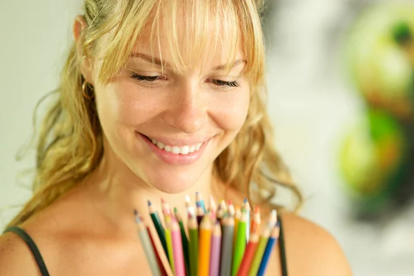 Νεαρή γυναίκα καλλιτέχνης κρατώντας χρωματιστά μολύβια και χαμογελαστός — Φωτογραφία Αρχείου