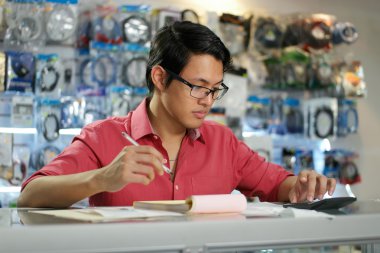 Faturaları ve faturaları kontrol bilgisayar dükkanda Çinli adam