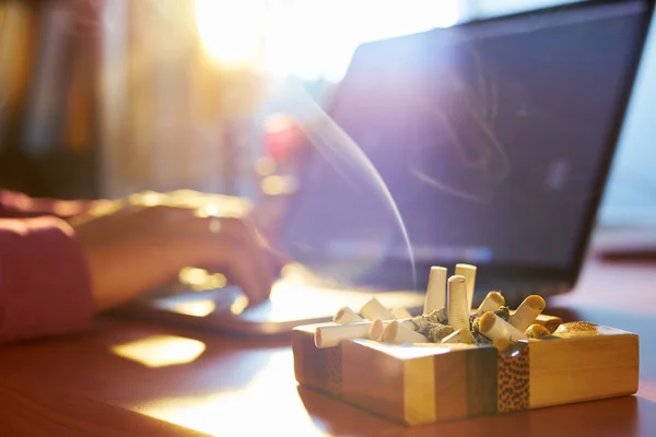 Man använder Laptop och röka cigarett på morgonen — Stockfoto