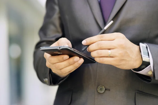 Hombre de negocios escribiendo con la pluma en el teléfono inteligente Phablet —  Fotos de Stock