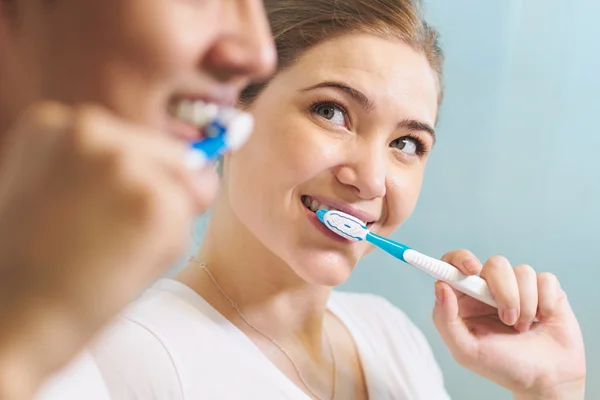 Пара стирающих зубов мужчина и женщина вместе в ванной комнате — стоковое фото