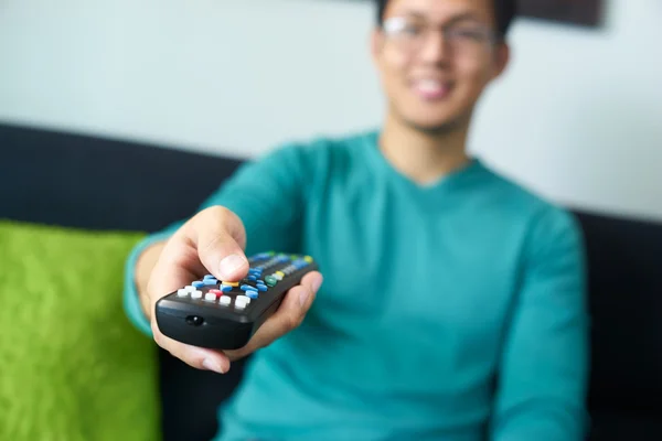 Asiático hombre viendo tv cambios canal con remoto —  Fotos de Stock