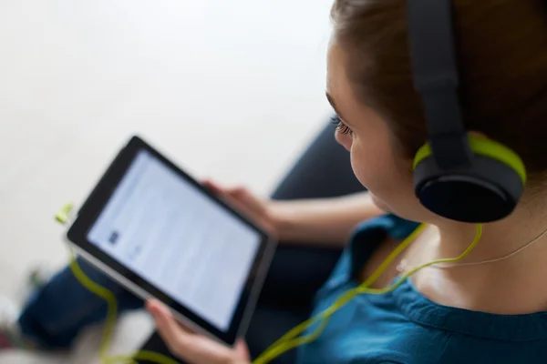 Kvinna med gröna hörlurar lyssnar Podcast musik TabletPC — Stockfoto