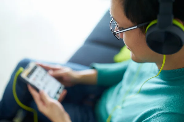 Ασιατικό άτομο με πράσινο ακουστικά ακούει μουσική τηλέφωνο Podcast — Φωτογραφία Αρχείου