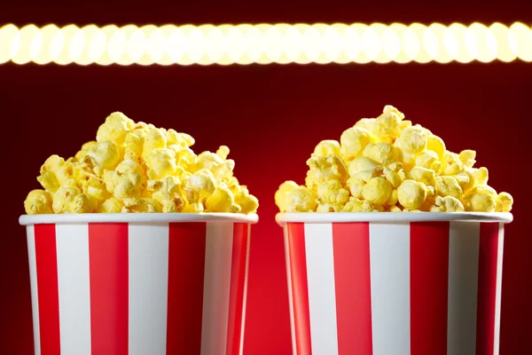 Schalen gefüllt mit Popcorn für Filmabend roter Hintergrund — Stockfoto