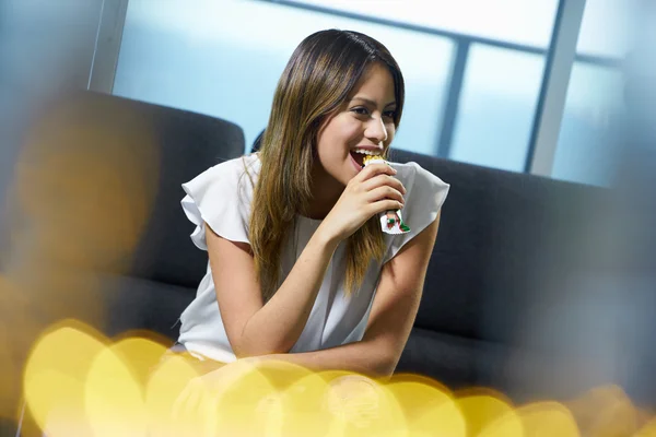 Woman Sitting At Home Eating Low Fat Cereal Bar — Stock Photo, Image