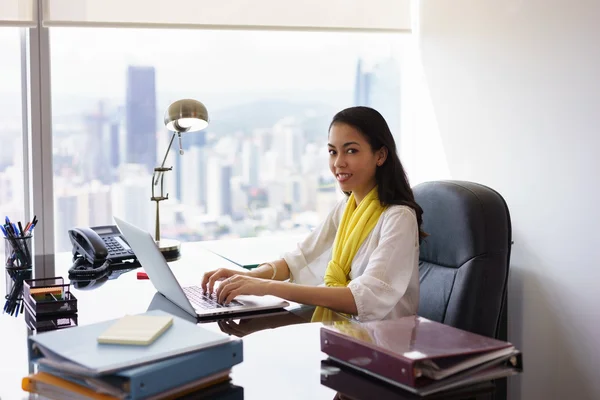 Mujer de negocios Asistente escribiendo en PC y sonriendo en la cámara — Foto de Stock