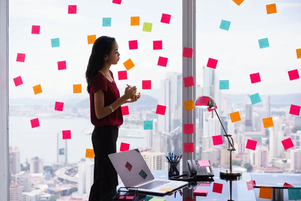 Secretario de organización de tareas de escritura de notas adhesivas en la ventana — Foto de Stock