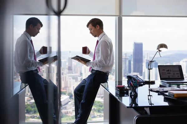 Business Person drycker kaffe och läser nyheter på Tablet PC — Stockfoto