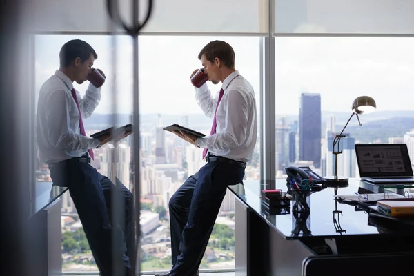 Personne d'affaires avec tasse de café lecture Nouvelles sur tablette — Photo