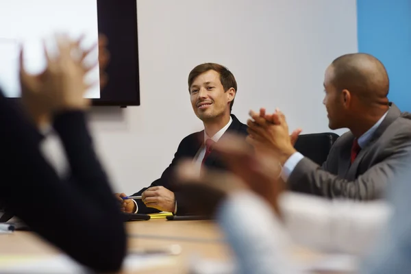 Affärsman gör presentationen och människor applåderar i möte — Stockfoto