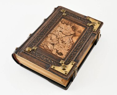 Ön kapağında eski dünya haritası olan kahverengi deri bir kitap. Çerçeveyi ve pirinç köşeleri kabartmış.
