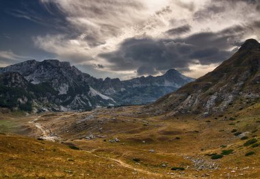 Gün batımında dağlarla ve bulutlarla kaplı bir manzara. Görüntü Karadağ 'ın yüksek ve Durmitor Dağı' nda çekildi.