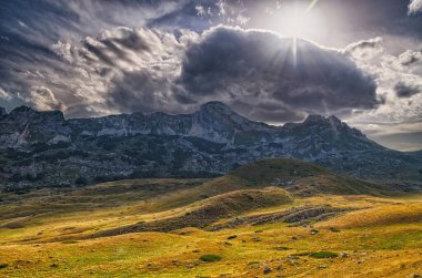 Gün batımında dağlarla ve bulutlarla kaplı bir manzara. Görüntü Karadağ 'ın yüksek ve Durmitor Dağı' nda çekildi.