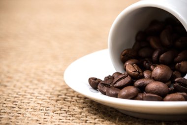 Beyaz coffeecup ve plaka ile dökülen coffeebeans