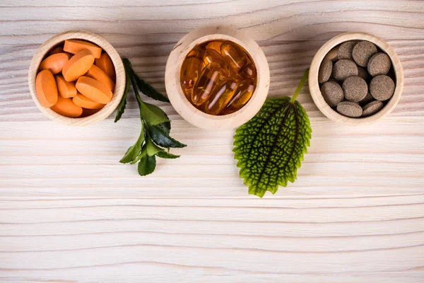 Різні гомеопатичні таблетки і зелене листя — стокове фото