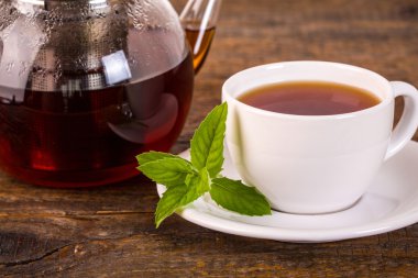 Ahşap masa üzerinde çaydanlık ile çay fincanı