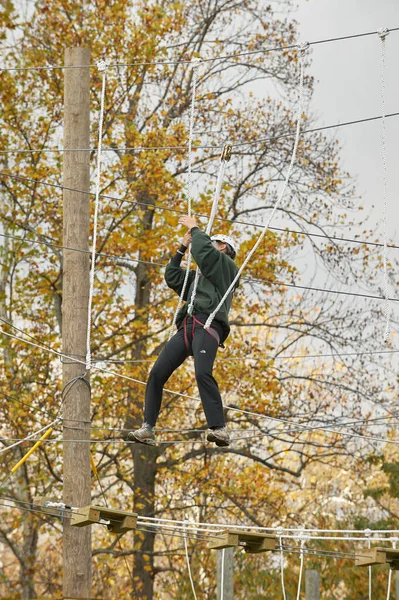 High ropes/challenge course.  Participant crossing guide wires