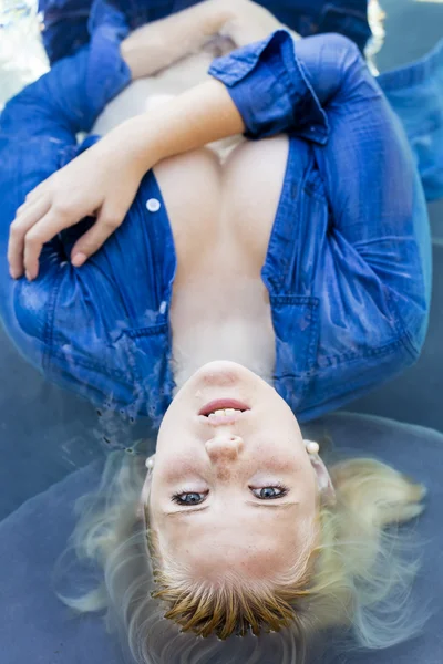 Loira modelo relaxante em uma piscina — Fotografia de Stock