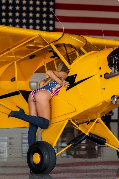 一个漂亮的金发模特和一架老式二战飞机合影 — 图库照片