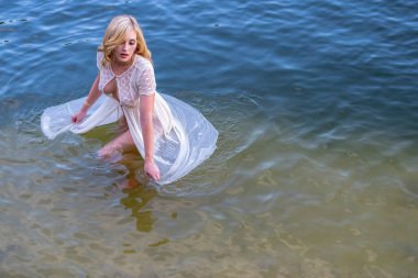 Muhteşem bir sarışın manken, yaz günlerinde gölün tadını çıkarıyor.