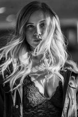 Muhteşem sarışın bir model, bir sonbahar günü park yerinde poz verir.