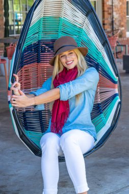 Sonbahar kıyafetleriyle dışarıda poz veren güzel bir sarışın manken.