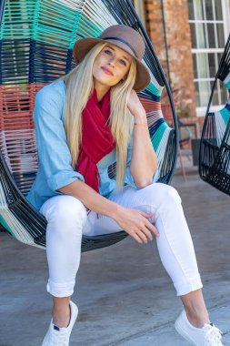 Sonbahar kıyafetleriyle dışarıda poz veren güzel bir sarışın manken.