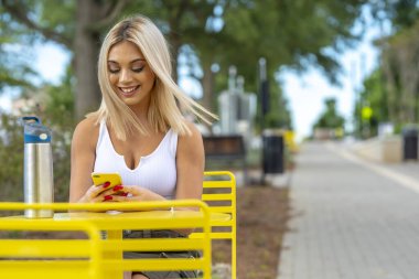 Sarışın bir model yaz gününün tadını çıkarırken dışarıda poz veriyor.