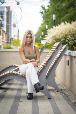 Sarışın bir model yaz gününün tadını çıkarırken dışarıda poz veriyor.