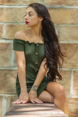 Muhteşem bir esmer model, açık havada bir bahar gününün tadını çıkarıyor. 