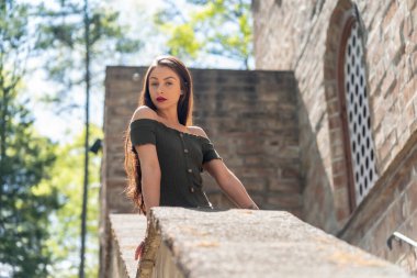 Muhteşem bir esmer model, açık havada bir bahar gününün tadını çıkarıyor. 