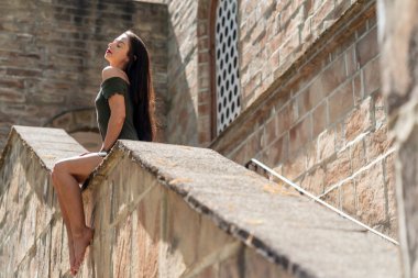 Muhteşem bir esmer model, açık havada bir bahar gününün tadını çıkarıyor. 