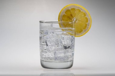Stüdyo ortamında limon dilimli bir bardak su.