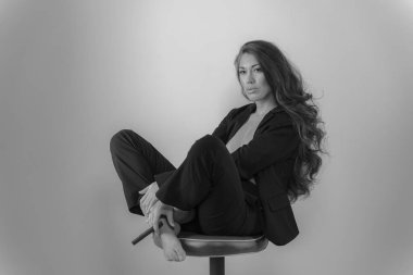 Stüdyo ortamında güzel bir karma ırk modeli iş elbisesi içinde poz verir.