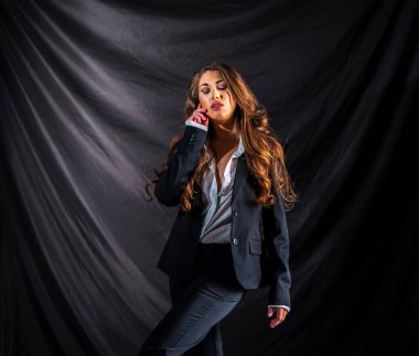 Stüdyo ortamında güzel bir karma ırk modeli iş elbisesi içinde poz verir.