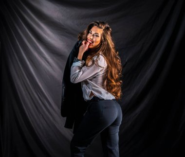 Stüdyo ortamında güzel bir karma ırk modeli iş elbisesi içinde poz verir.