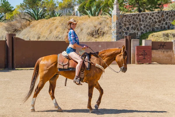 一个华丽的西班牙裔布鲁内特模特骑着一匹马在墨西哥的Hacienda户外 — 图库照片