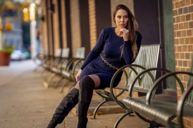 Muhteşem bir esmer model, sonbahar havasının tadını çıkarırken dışarıda poz veriyor.