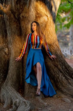 Muhteşem bir esmer model, sonbahar havasının tadını çıkarırken dışarıda poz veriyor.