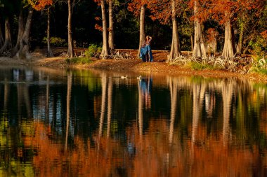 Muhteşem bir esmer model, sonbahar havasının tadını çıkarırken dışarıda poz veriyor.