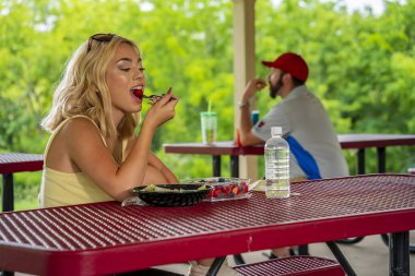 Sarışın bir manken, Covid-19 salgını sırasında diğerlerinden güvenli bir mesafede öğle yemeğinin tadını çıkarıyor.