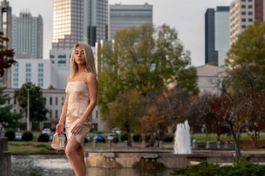 Genç ve güzel bir sarışın model, bir sonbahar gününün tadını çıkarırken dışarıda poz veriyor.