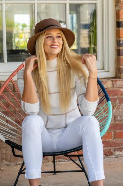 Sonbahar kıyafetleriyle dışarıda poz veren güzel bir sarışın manken.