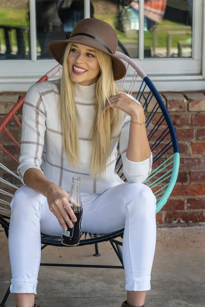 Sonbahar kıyafetleriyle dışarıda poz veren güzel bir sarışın manken.