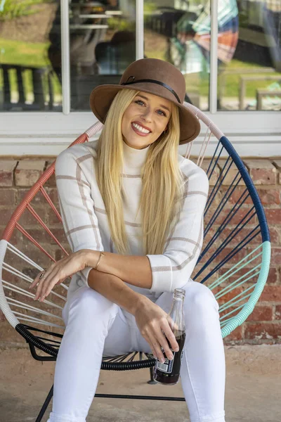 Sonbahar kıyafetleriyle dışarıda poz veren güzel bir sarışın manken.