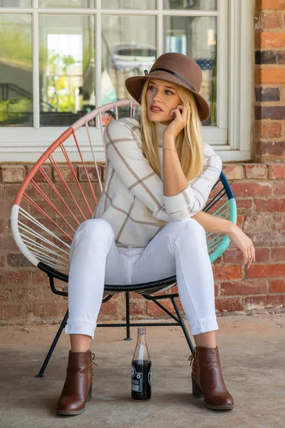 Sonbahar kıyafetleriyle dışarıda poz veren güzel bir sarışın manken.