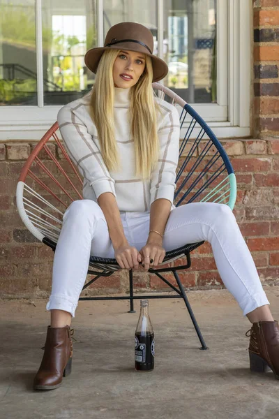 Sonbahar kıyafetleriyle dışarıda poz veren güzel bir sarışın manken.